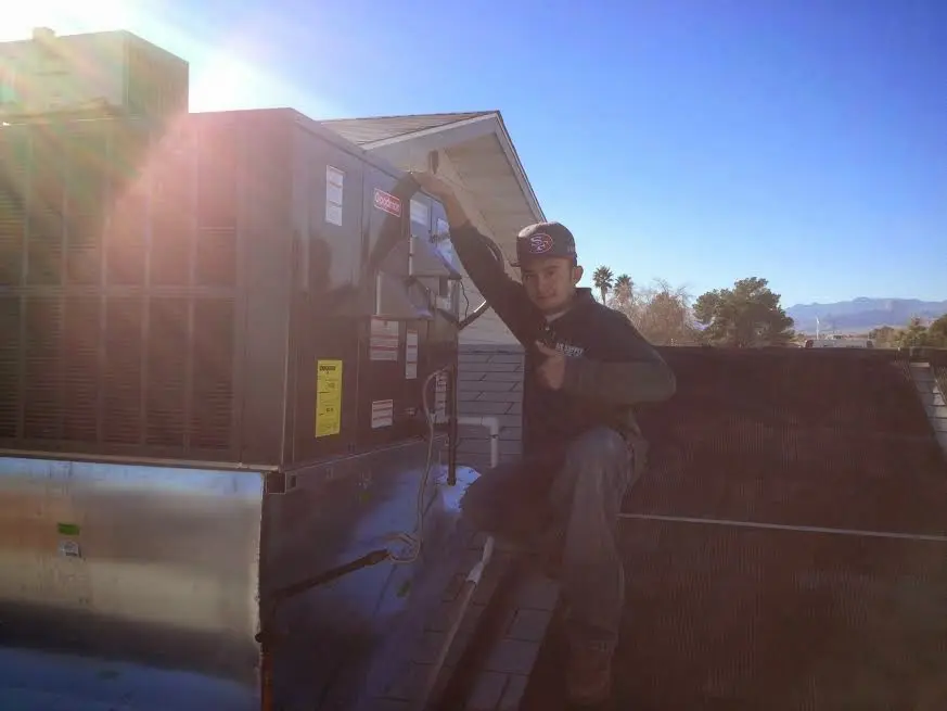 HVAC technician performing Heat Pump Repair on a rooftop unit in East Granby